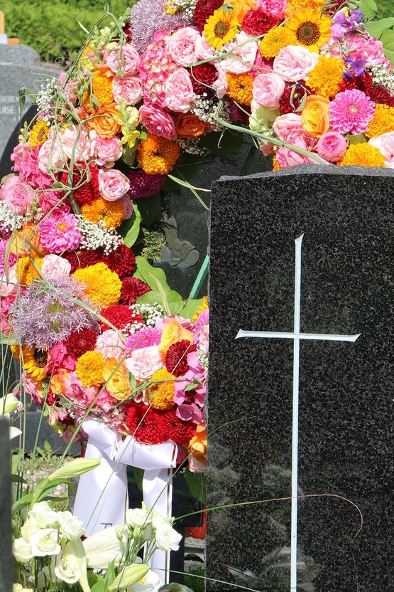 Trauerkranz mit bunten Blumen nach einer Besetzung am Friedhof, Grabpflege, Trauer, Tod, Floristik, christlicher Friedhof