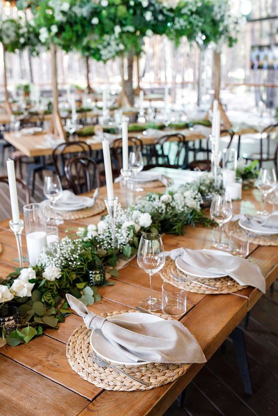 Festlicher Hochzeitstisch mit Blumen, Servietten, Besteck, Gläsern und Kerzen, helle Sommertischdekoration. Hochzeitsdekor