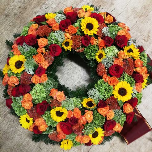 trauerfloristik-kranz-sonnenblumen-gerbera-rosen-gelb-rot