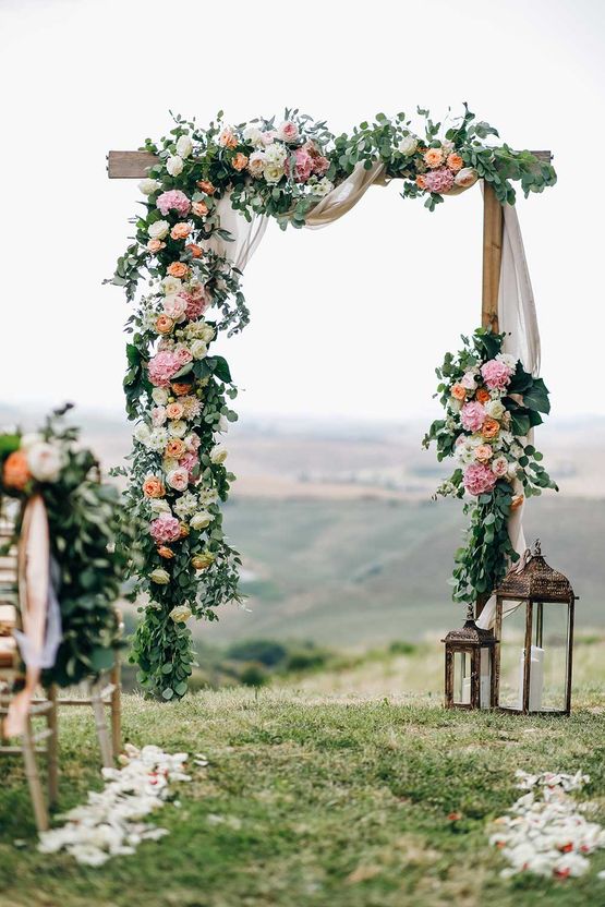 Italienische Hochzeitsdekoration. Grüner Eukalyptus, Orangen und rosa Blumen schmücken den Hochzeitsaltar